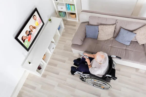 Бабушка-инвалид смотрит телевизор — стоковое фото