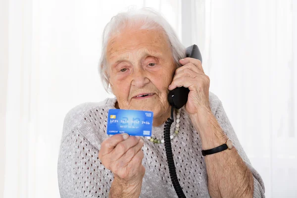 फोन पर क्रेडिट कार्ड के साथ वरिष्ठ महिला — स्टॉक फ़ोटो, इमेज