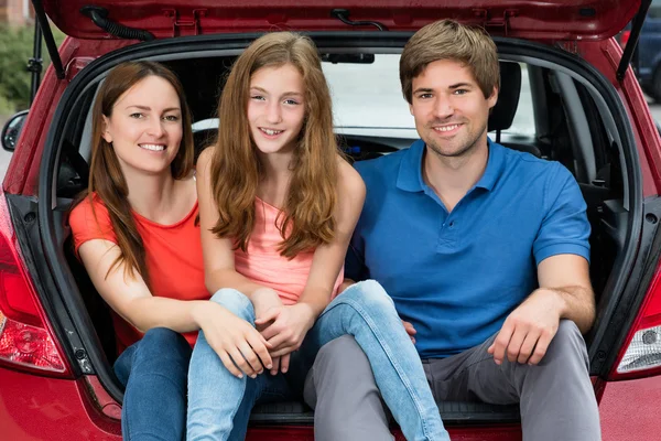 Famiglia seduta nel bagagliaio della loro auto — Foto Stock