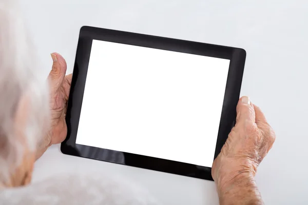 Äldre kvinna anläggning digital tablet — Stockfoto