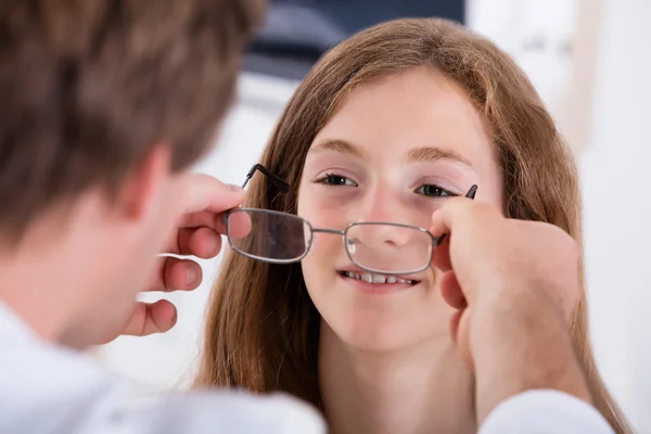 Uma menina de ajuda óptica com óculos novos — Fotografia de Stock