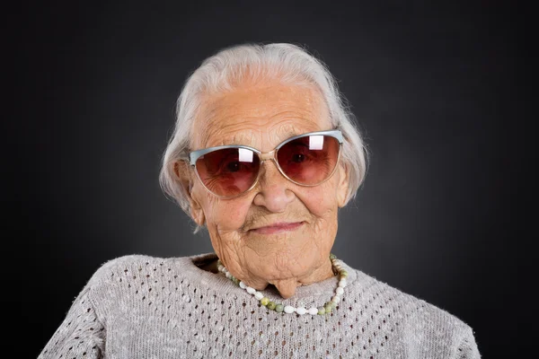 Пожилая женщина в солнечных очках — стоковое фото