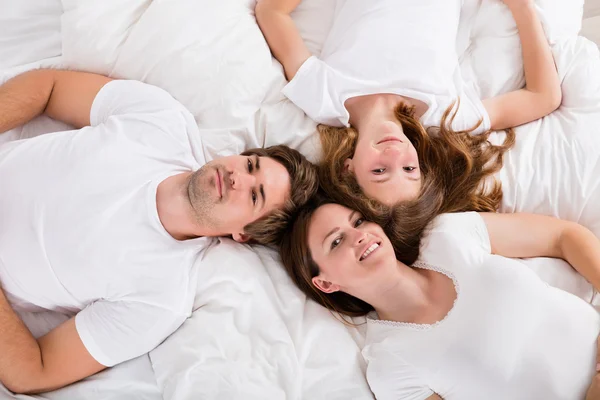 Familie liegt auf Bett — Stockfoto