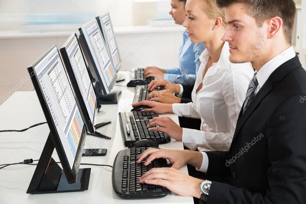 Businesspeople Typing On Desktop Computers