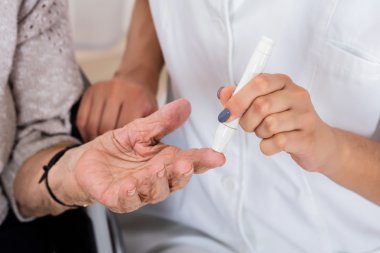 Doktor Holding hastanın kontrol şeker seviyesi parmak