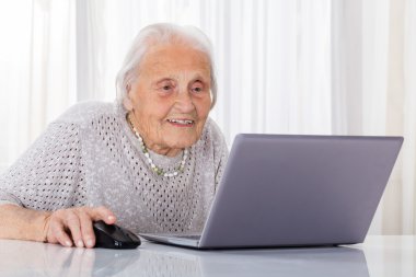 Dizüstü bilgisayar kullanan yaşlı kadın.