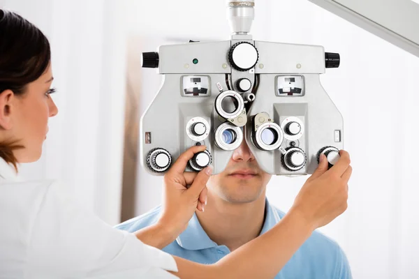 Optometrista che regola il Phoropter per il paziente — Foto Stock