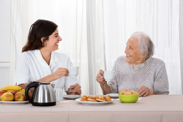 Dos mujeres disfrutando del té y las galletas —  Fotos de Stock