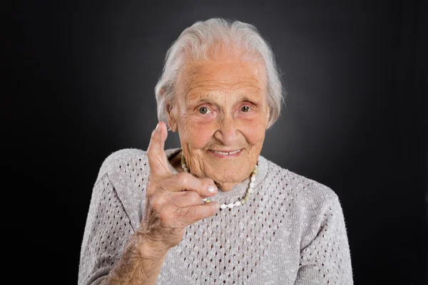 Femme âgée souriante agitant son doigt — Photo