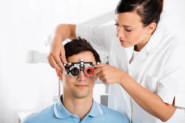 Női optometrista ellenőrzése a beteg látását — Stock Fotó