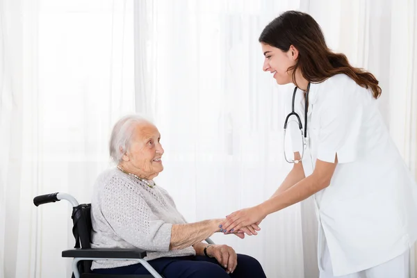 Dokter troostende handicap Senior patiënt — Stockfoto