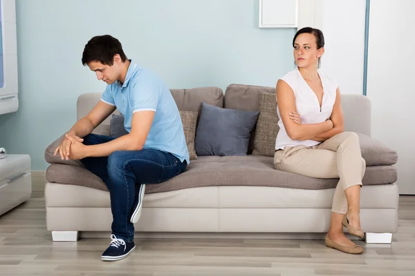 Couple Sitting Back To Back On Sofa — Stock Photo, Image