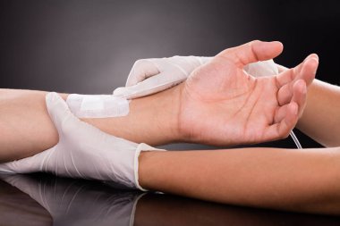 Doktor hastanın elini tutuyor. 