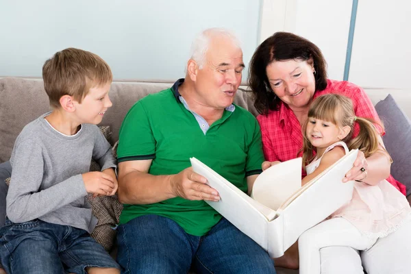 Grootouders en kleinkinderen kijken naar foto 's — Stockfoto