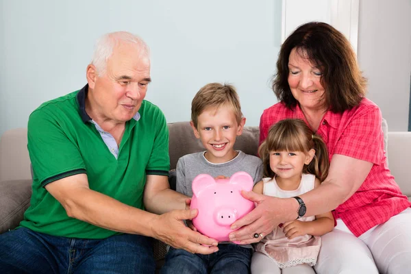 Familie Holding spaarpot thuis — Stockfoto