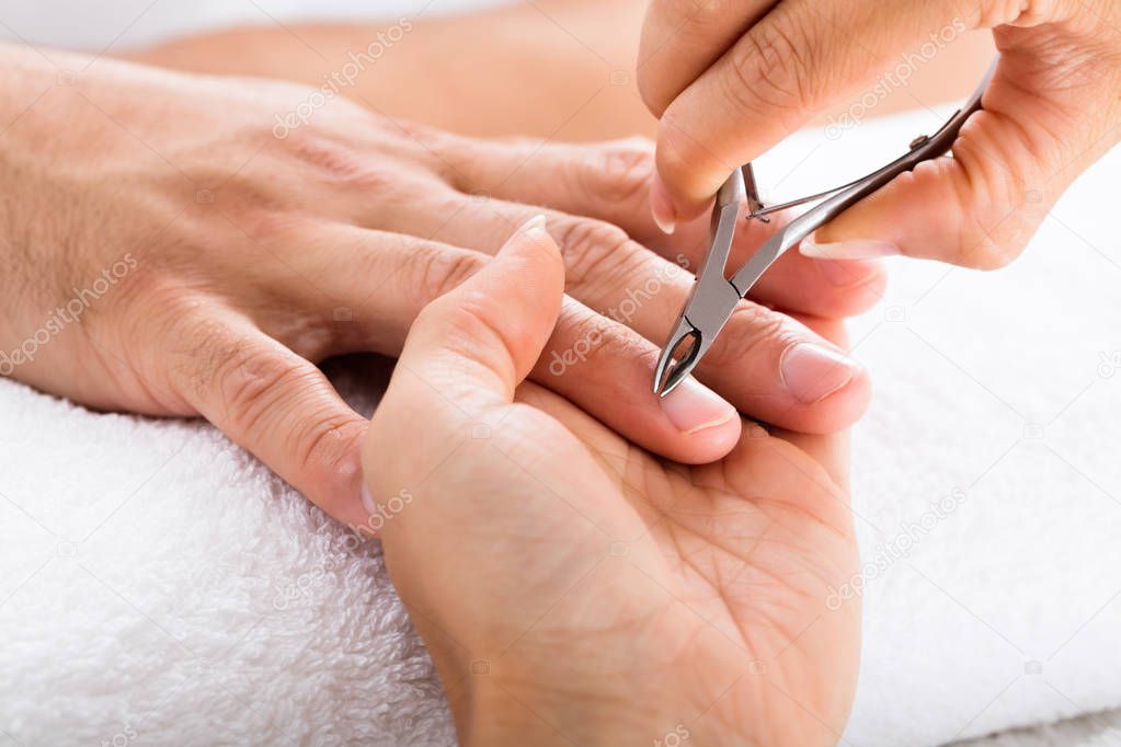 Manicurist doing Trimming of Male nails 