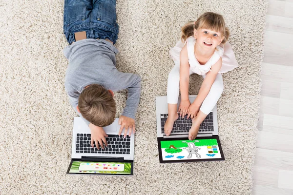 Двое детей с ноутбуками — стоковое фото