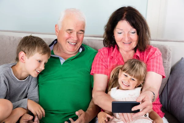 Бабушка с дедушкой и внуки проводят время вместе — стоковое фото