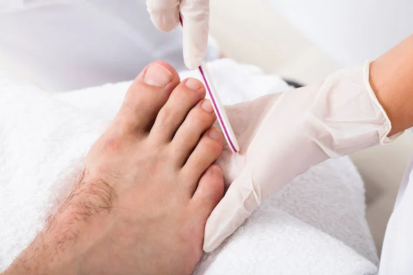 Manicura haciendo recorte de uñas de los pies masculinos —  Fotos de Stock