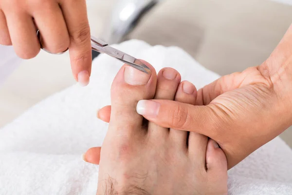 Manicura haciendo recorte de uñas de los pies masculinos —  Fotos de Stock