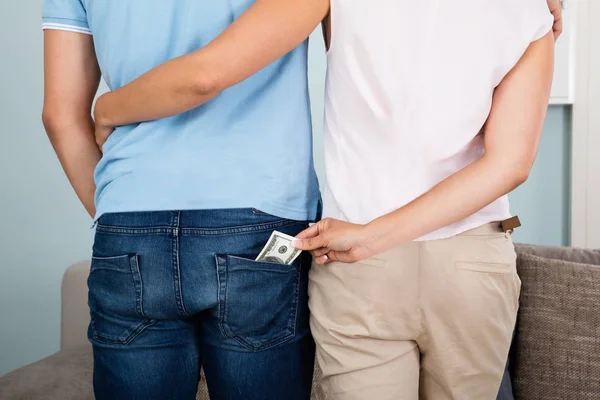 Kobieta, kradzież pieniędzy z kieszeni męża — Zdjęcie stockowe