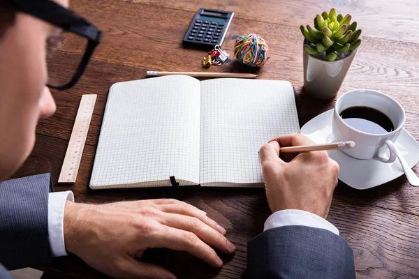 Homem de negócios escrevendo no notebook — Fotografia de Stock