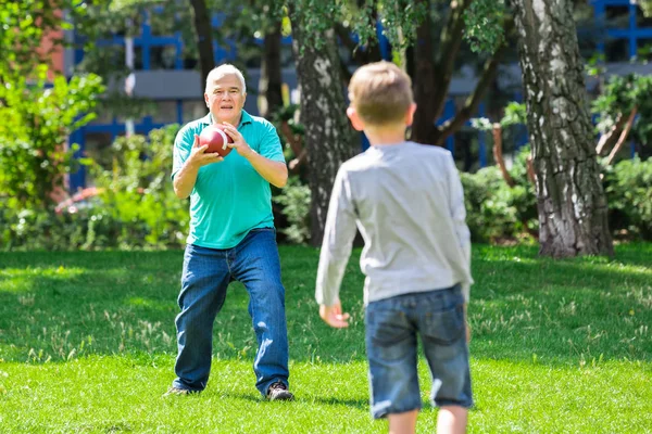 Enkel und Großvater spielen Rugby — Stockfoto