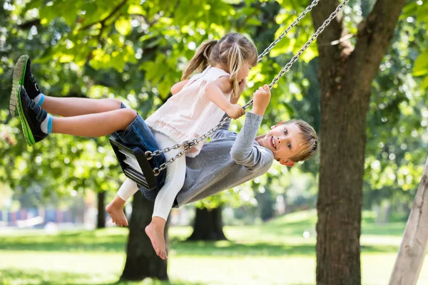 Broer en zus genieten op Swing — Stockfoto