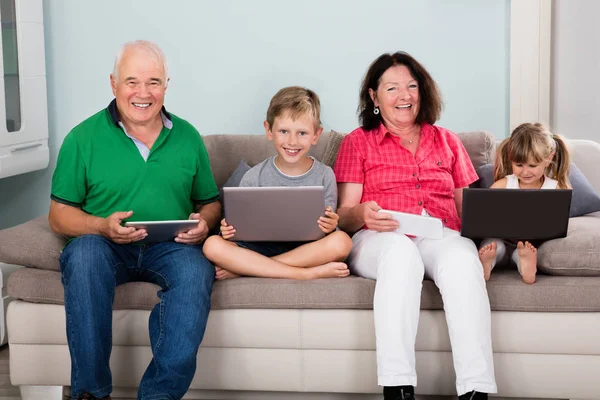Famiglia seduta con computer portatile — Foto Stock