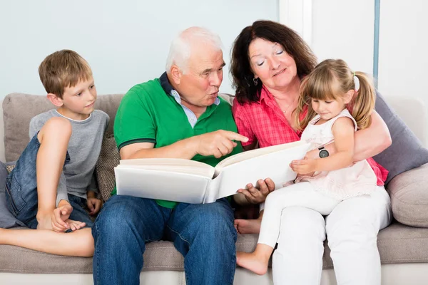 Familia mirando álbum de fotos — Foto de Stock