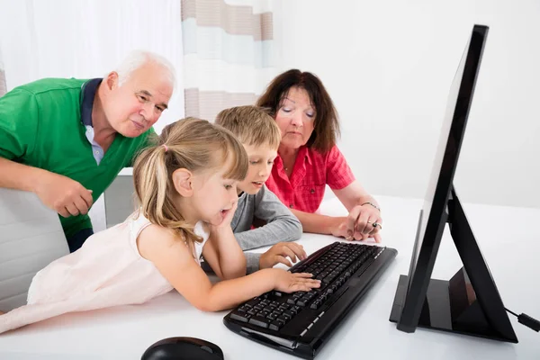 Familia usando computadora de escritorio — Foto de Stock