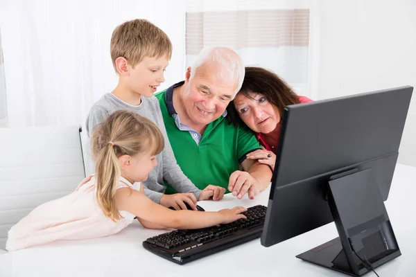 Famille utilisant un ordinateur de bureau — Photo