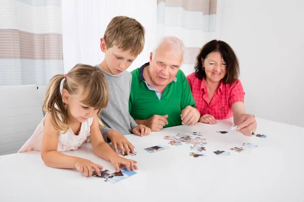 Família resolvendo puzzle juntos — Fotografia de Stock