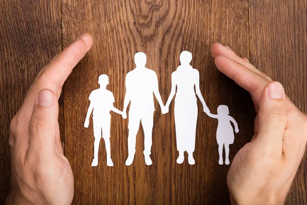 Handen beschermen familie papercut — Stockfoto