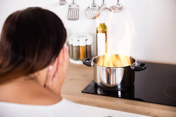 Mujer sosteniendo olla con fuego — Foto de Stock