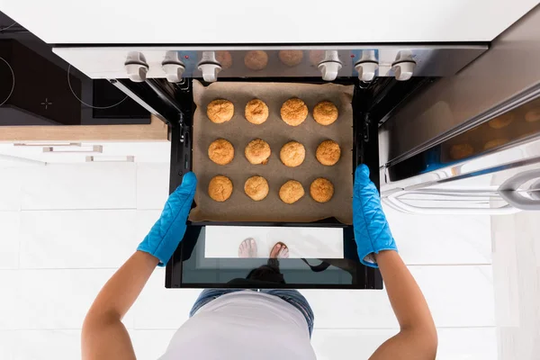 Mulher assar biscoitos no forno — Fotografia de Stock