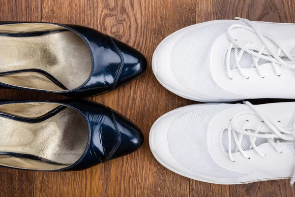 Par de sandalias negras y zapatos blancos — Foto de Stock