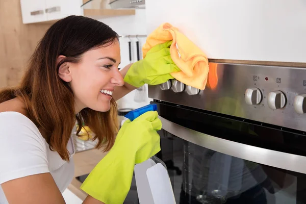 Woman cleaning oven in kitchen — Stock Photo, Image