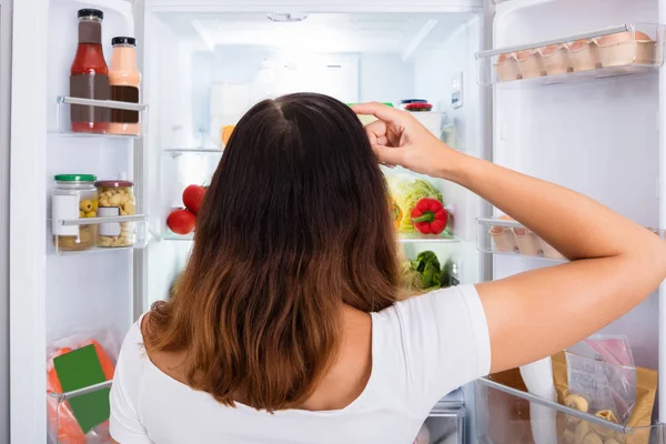 Förvirrad kvinna söker efter mat — Stockfoto