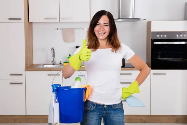 Женщина с помощью оборудования для уборки на кухне — стоковое фото