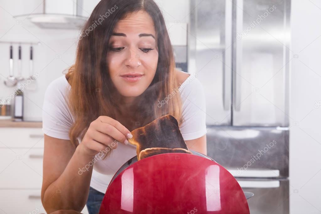 Woman taking burnt toast