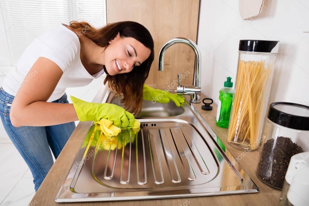 Female cleaning stainless steel sink