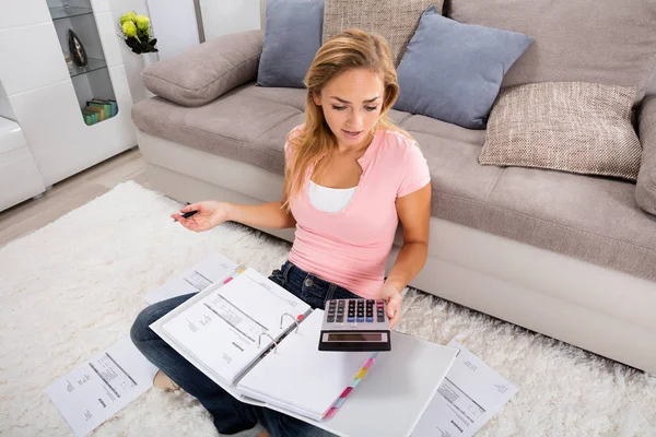 Mujer mirando calculadora — Foto de Stock