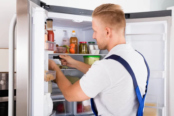 Ремонтник проверяет холодильник — стоковое фото