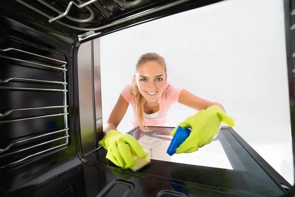 Mulher limpeza dentro do forno — Fotografia de Stock