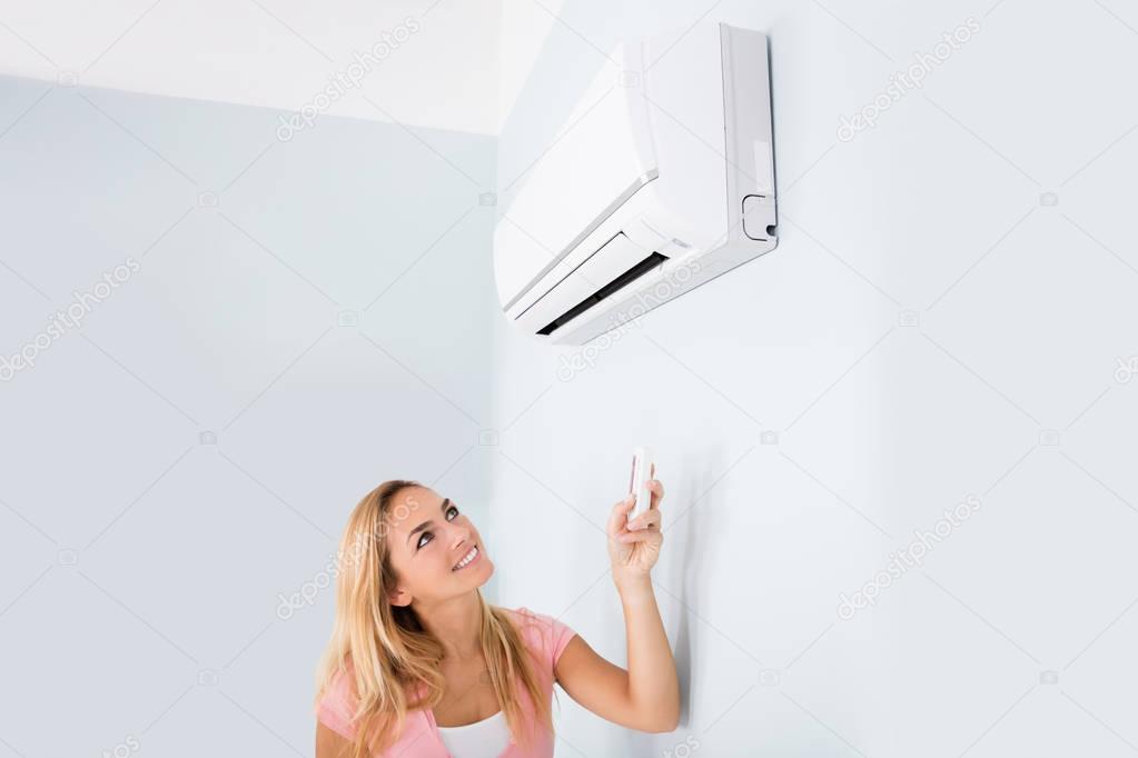 Woman Operating Air Conditioner