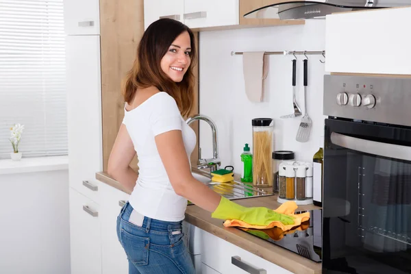 Kobieta, czyszczenie kuchenki indukcyjne — Zdjęcie stockowe