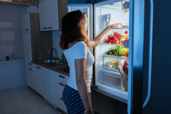 Mujer mirando en refrigerador —  Fotos de Stock