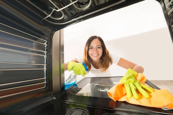 女人在烤箱内清洗 — 图库照片