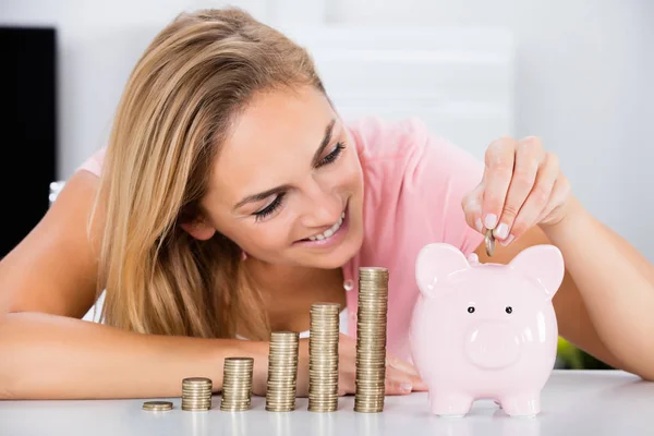 Woman Inserting Coin In Piggybank — Stock Photo, Image